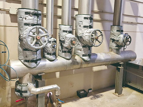 Steam header with multiple globe valves and flange connections insulated using removable, reusable blanket insulation (jacket insulation).