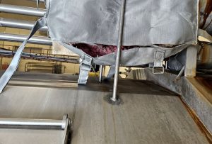 Damaged removable insulation blanket with exposed internal insulation in a food-processing facility