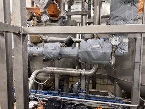 Removable insulation blankets fitted around valves and process components in a food-processing facility